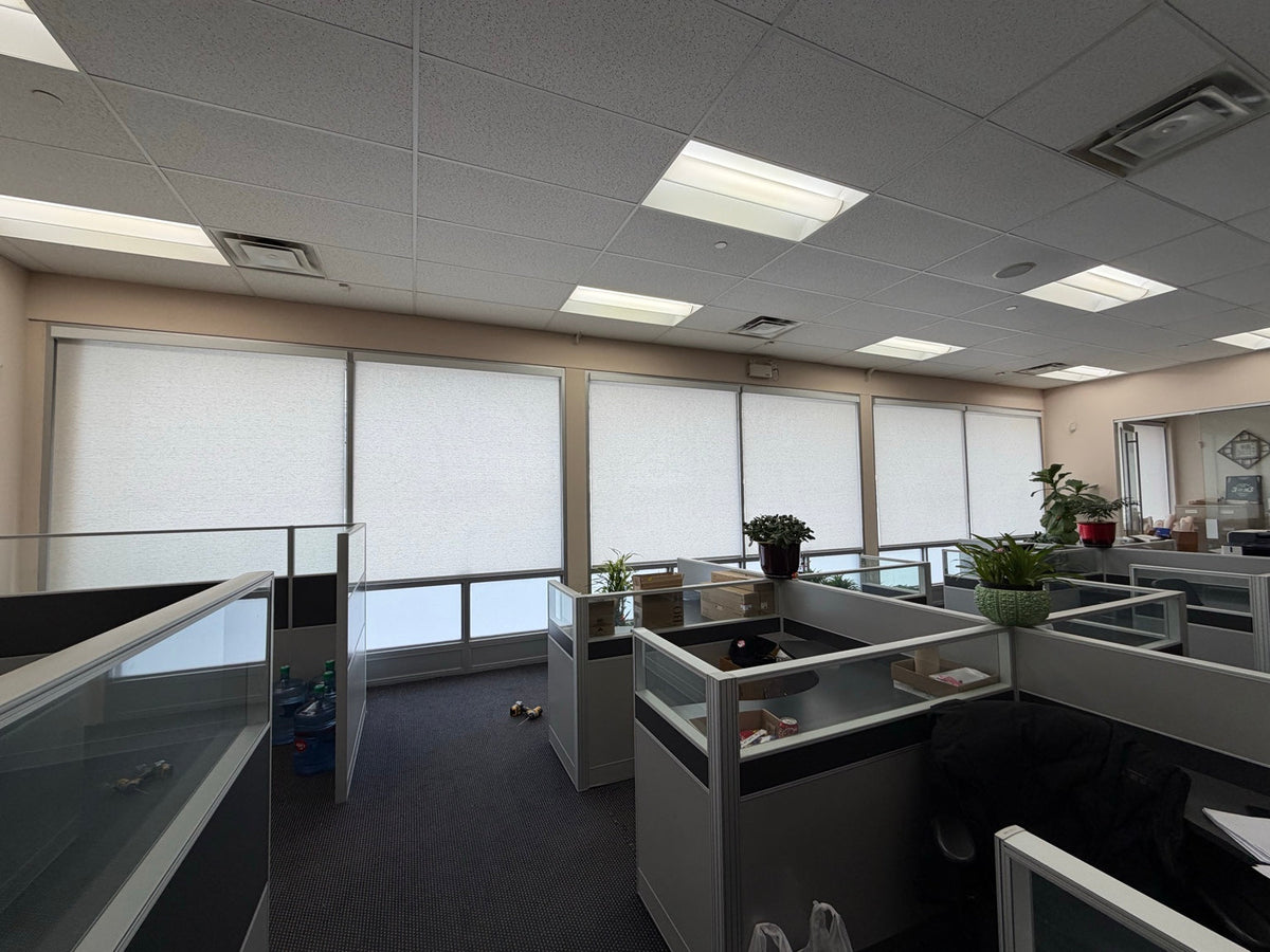 White roller shades installed in a bright condo interior.