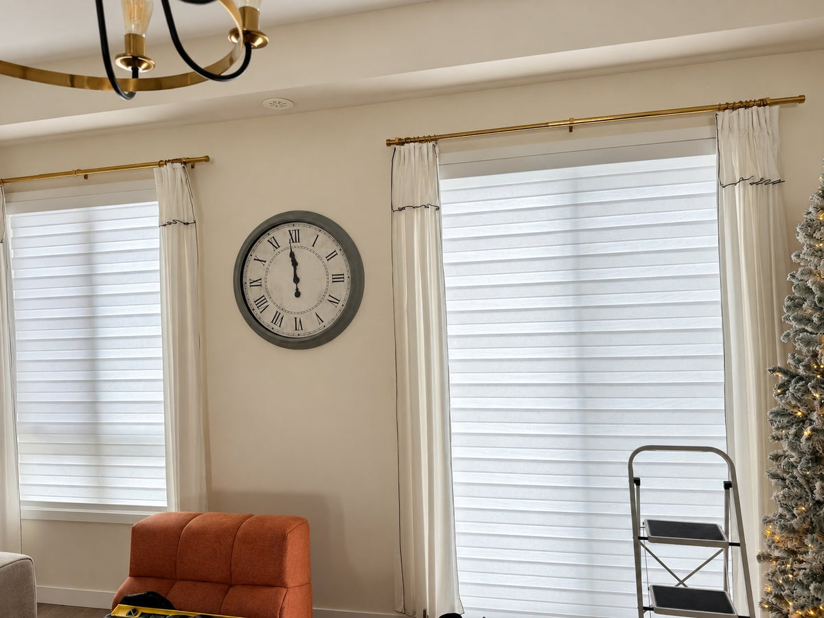 White zebra blinds across the windows of an open living space.