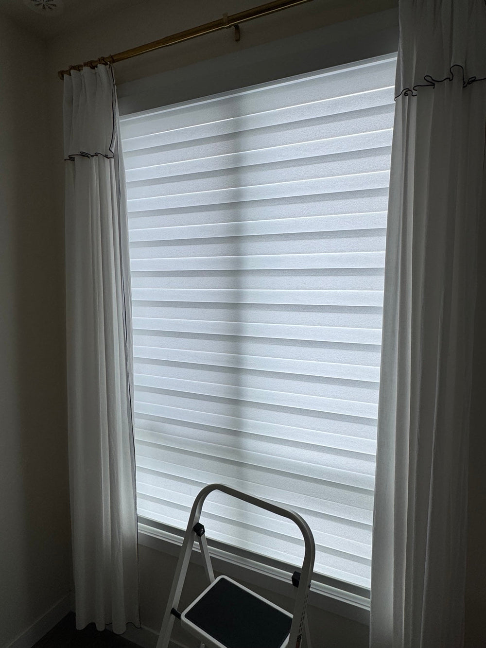 White zebra blinds fitted to two tall windows.